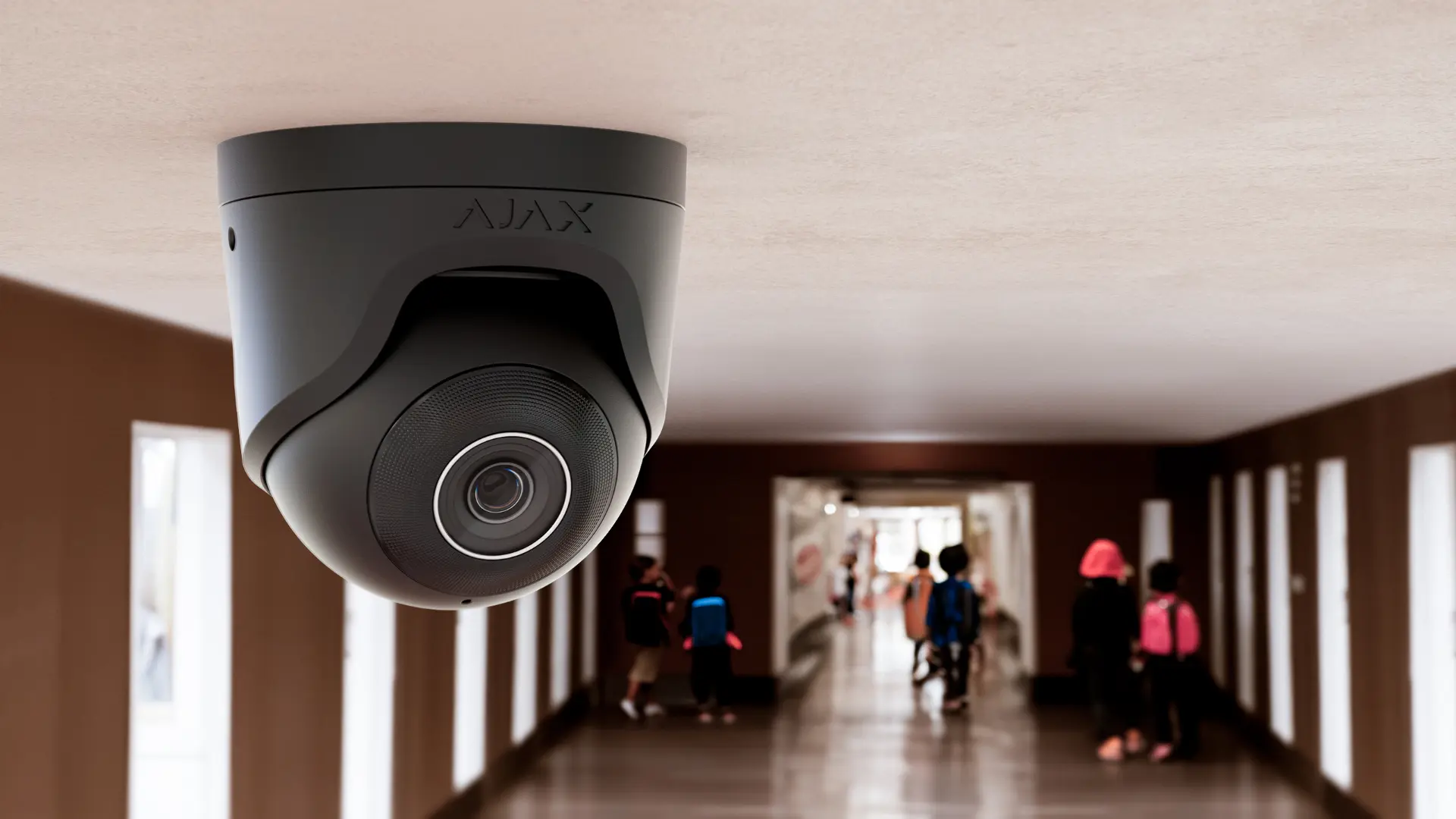 Ajax dome camera on a school corridor ceiling with pupils walking below