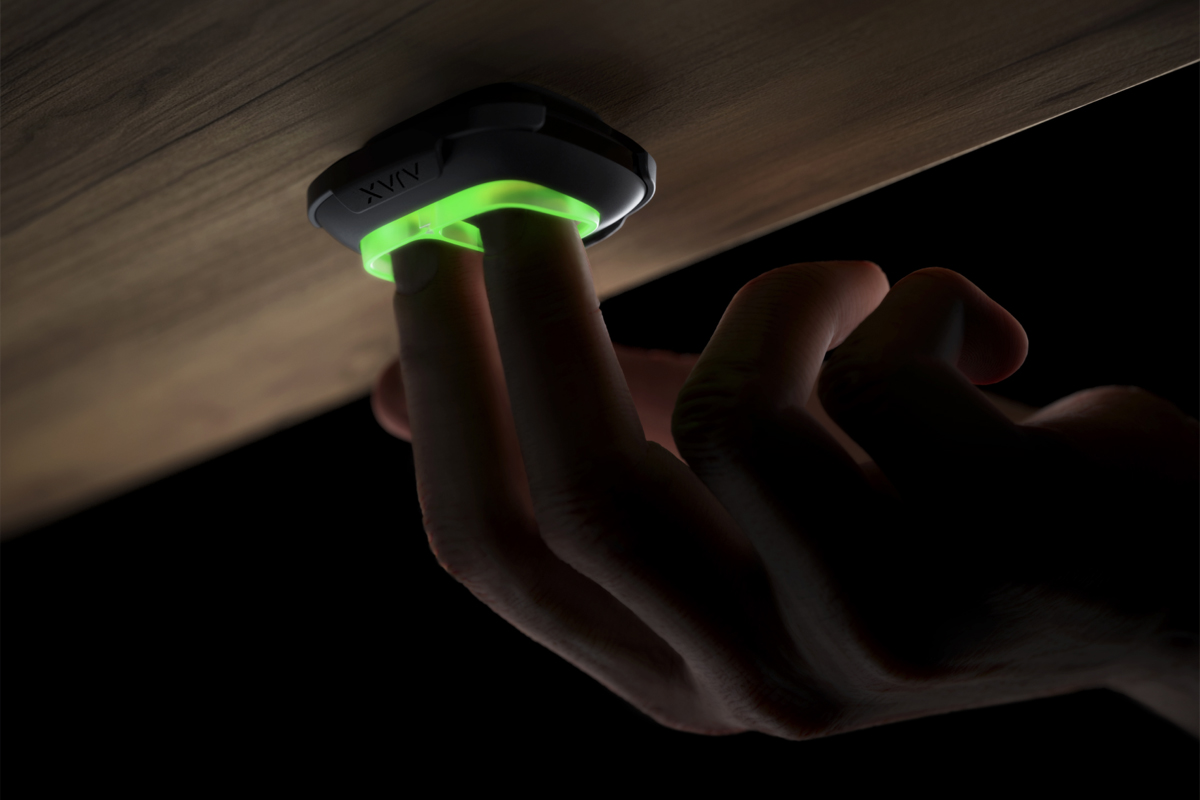 Ajax wireless panic button fitted discreetly underneath a desk, pressed by a member of staff